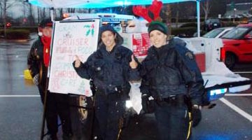 RCMP Members in front of police cruiser with thumbs up