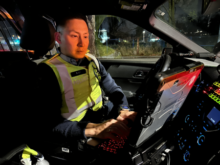 photo d’un agent dans un véhicule de police tapant sur un terminal de données mobile